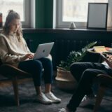 a woman sitting in a chair with a laptop