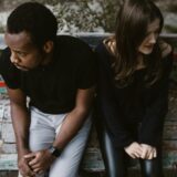 a man and woman sitting on a bench