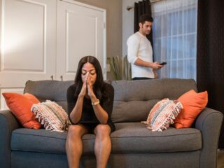 Interracial, Intercultural & Interfaith Relationship Counseling in Virginia A man and woman experiencing emotional turmoil and separation in a living room setting.
