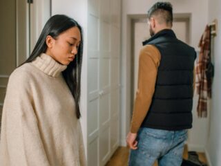 A couple experiencing relationship issues in a hallway, conveying emotional tension.