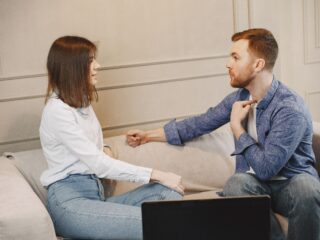 Couple sitting on couch facing each other
